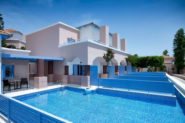 Ein blauer Swimmingpool mit einer Reihe von blauen Barrieren, umgeben von einem Gebäude im griechischen Stil.