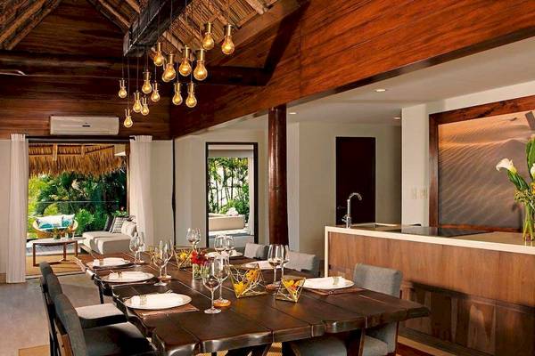 Innenansicht des Esszimmers im Secrets Papagayo Costa Rica Hotel mit langem Esstisch, Stühlen und moderner Einrichtung.