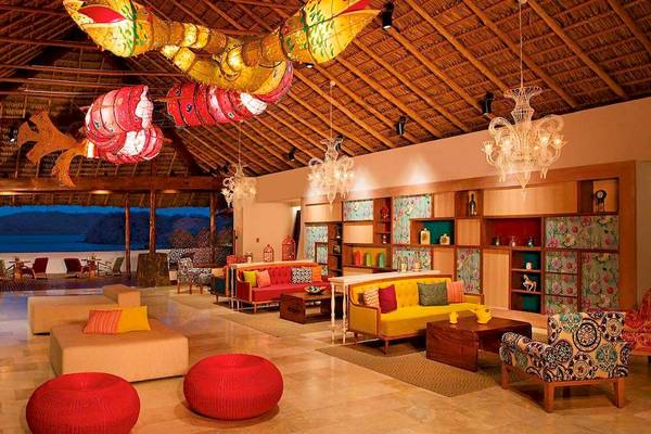 Lobby des Secrets Papagayo Costa Rica Hotels mit bunten Dekorelementen und modernen Möbeln.