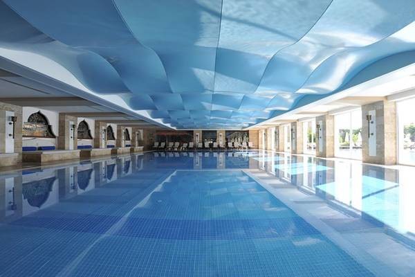 Innenansicht des Swimmingpools im Nirvana Dolce Vita Hotel mit blauen Deckenverkleidungen.