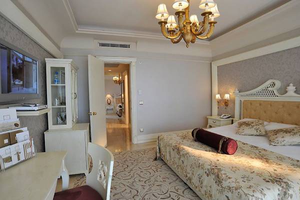 Schlafzimmer im Nirvana Dolce Vita Hotel mit großem Bett, Nachttischen und Fernseher.
