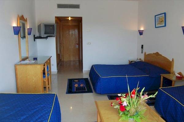 Hotelzimmer im Mahdia Beach & Aqua Park mit zwei Betten, Tisch, Fernseher und Dekor.