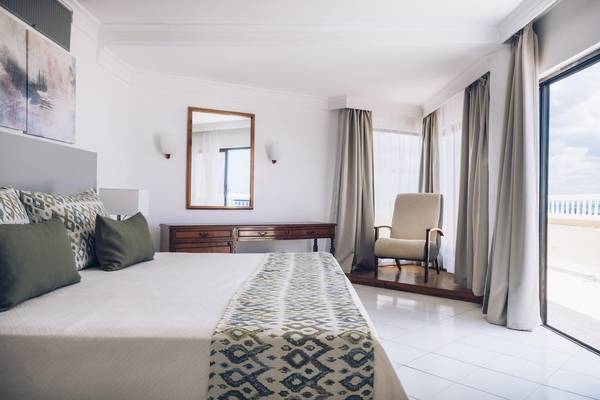 Hotelzimmer im Iberostar Origin Bella Costa mit Bett, Nachttisch und Aussicht.
