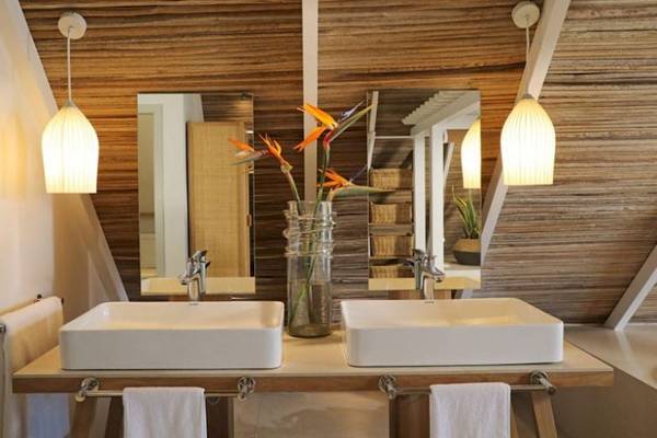 Badezimmer im Preskil Island Resort mit zwei Waschbecken, Spiegeln und Holzwänden.