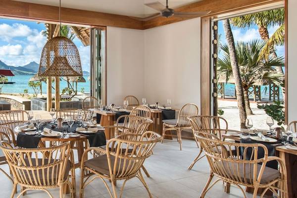 Innenansicht des Restaurants im Preskil Island Resort mit Blick auf das Meer und eine tropische Landschaft.