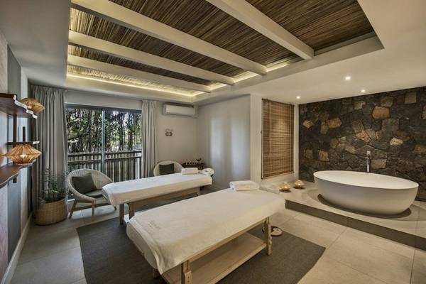 Spa-Behandlungsraum im Preskil Island Resort mit zwei Massagetischen und einer Badewanne.
