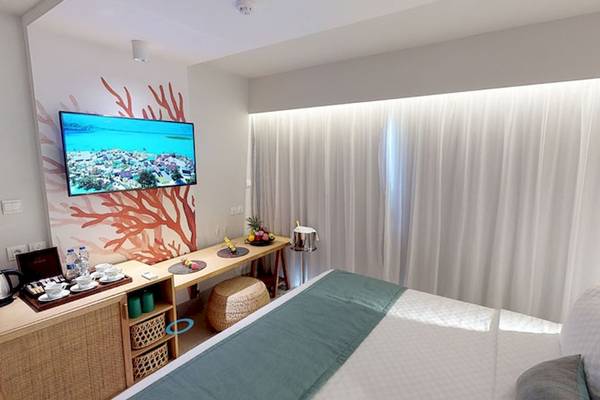 Innenansicht eines Hotelzimmers im Preskil Island Resort mit einem Fernseher und einem Schreibtisch.