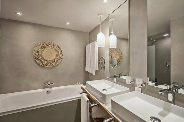 Badezimmer im Preskil Island Resort mit Badewanne, zwei Waschbecken und Spiegeln.