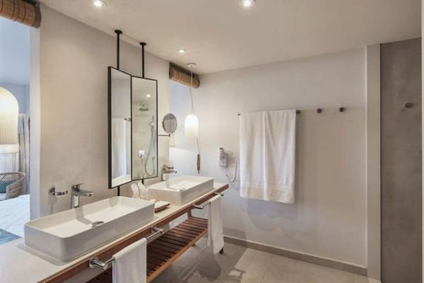 Badezimmer im Preskil Island Resort mit zwei Waschbecken, Spiegeln und Handtüchern.