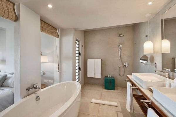 Badezimmer im Preskil Island Resort mit Badewanne, Dusche und Doppelwaschbecken.