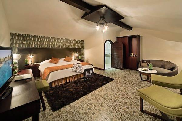BM Beach Resort Schlafzimmer mit Bett, Fernseher, Sesseln und Tisch