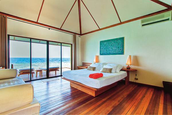 Schlafzimmer im Nakai Maayafushi Resort mit Blick auf das Meer und Möbeln.