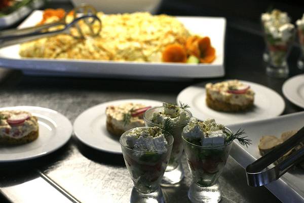 Tisch mit verschiedenen Gerichten im Minos Mare Hotel, darunter Salate und Vorspeisen in Gläsern.