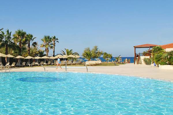 Poolbereich im Minos Mare Hotel mit Sonnenschirmen und Liegestühlen.