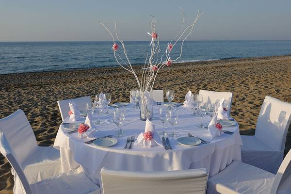 Ein Tisch auf dem Strand, dekoriert für eine Veranstaltung im Minos Mare Hotel.