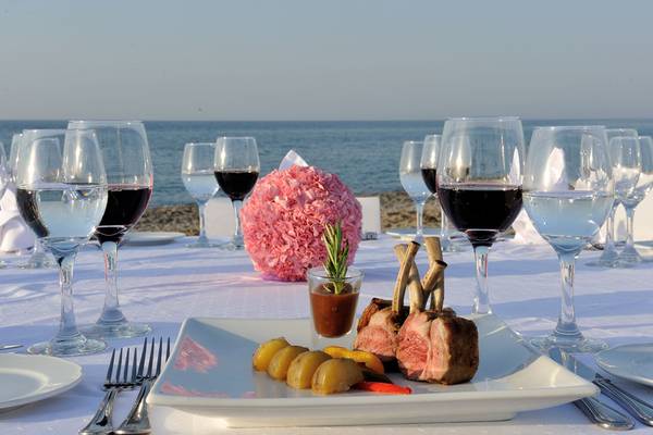 Tisch am Strand im Hotel Minos Mare mit Gericht, Wein und Meeresblick