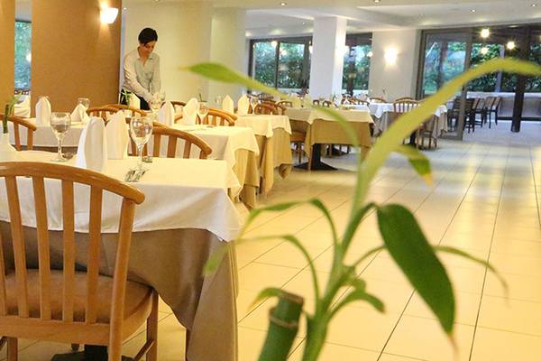 Innenansicht des Restaurants im Minos Mare Hotel mit gedeckten Tischen und Stühlen.