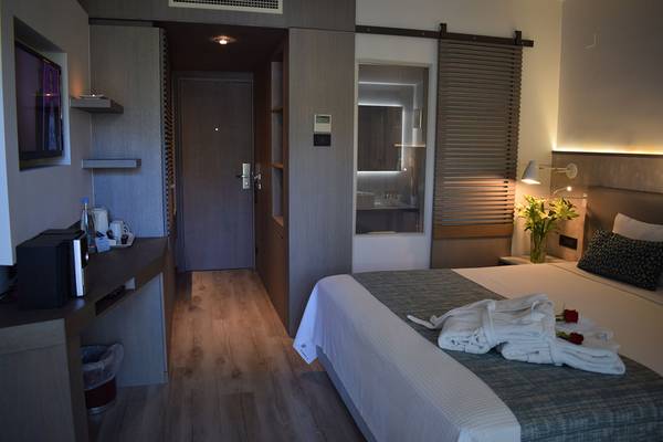 Innenansicht eines Zimmers im Minos Mare Hotel mit Doppelbett, Fernseher, Schreibtisch und Badezimmer