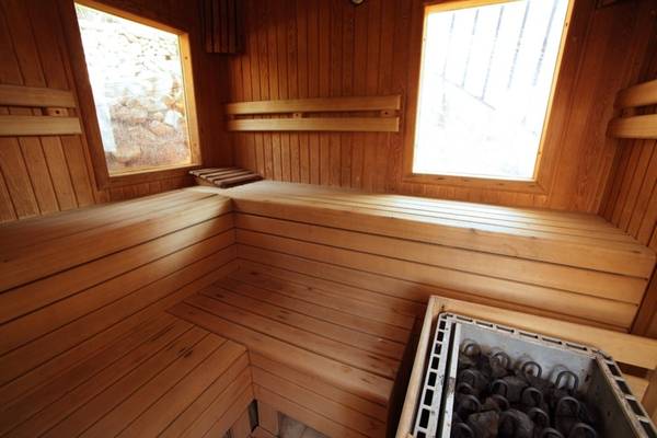 Innenansicht einer Holzsauna im Marble Arch Hotel By Perili Datca mit zwei Fenstern und Holzbänken
