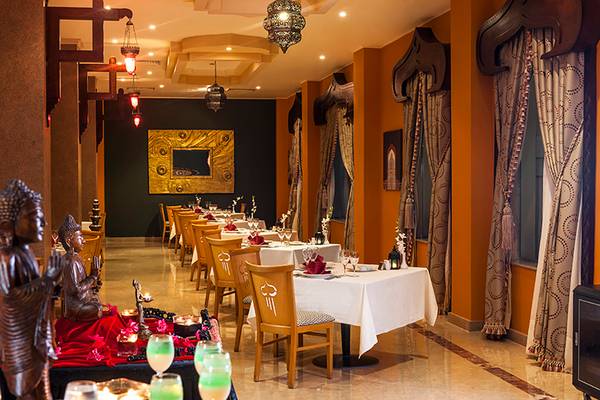 Innenansicht eines Restaurants im Rixos Sharm El Sheikh Hotel mit dekorierten Tischen und Stühlen.