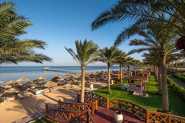 Strand mit Palmen und Sonnenschirmen im Rixos Sharm El Sheikh
