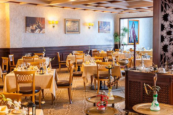 Restaurant im Rixos Sharm El Sheikh mit gedeckten Tischen und traditioneller orientalischer Dekoration.