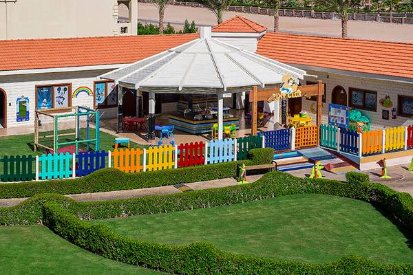 Luftaufnahme des Rixos Sharm El Sheikh Kinderclubs mit buntem Zaun und Spielplatz.