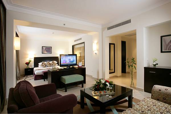 Innenansicht eines Zimmers im Rixos Sharm El Sheikh Hotel mit Bett, Fernseher und Wohnzimmermöbeln.
