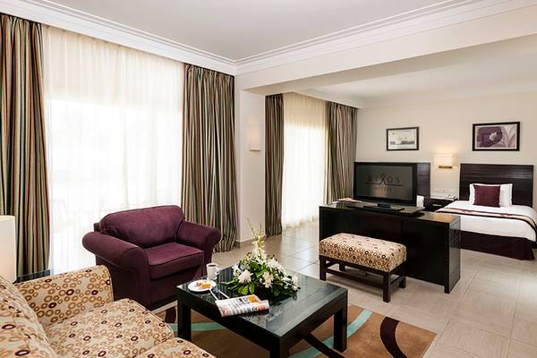 Hotelzimmer des Rixos Sharm El Sheikh mit Bett, Fernseher, Sessel und Tisch.