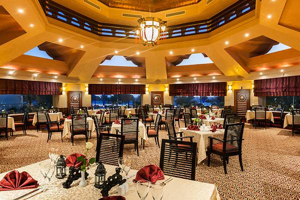Innenansicht des Restaurants im Rixos Sharm El Sheikh Hotel mit gedeckten Tischen und Stühlen.