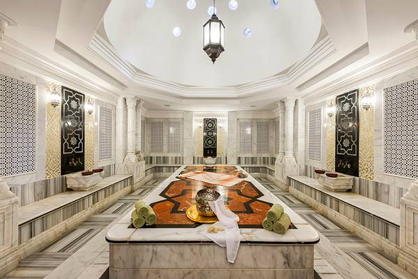 Innenansicht des Spas im Rixos Sharm El Sheikh Hotel mit Marmorboden, gemusterten Wänden und einer zentralen Liegefläche.