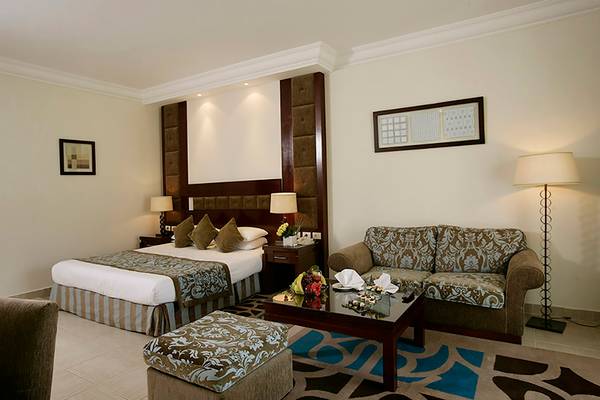 Hotelzimmer mit Doppelbett, Sofa, Tisch und Lampe im Rixos Sharm El Sheikh
