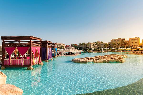 Pool mit bunten Sonnenschirmen und felsigen Inseln im Rixos Sharm El Sheikh