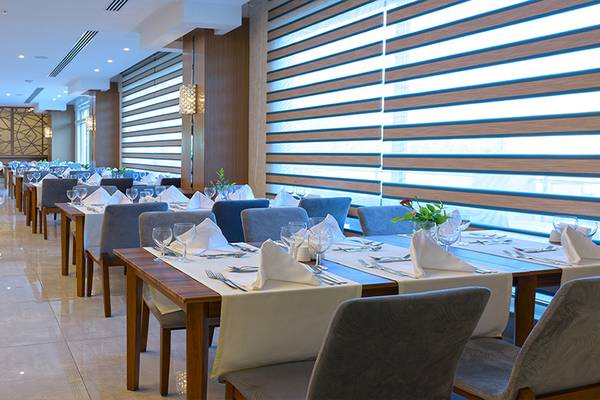 Innenansicht des Restaurants im Asia Beach Resort & Spa mit gedeckten Tischen und Stühlen.