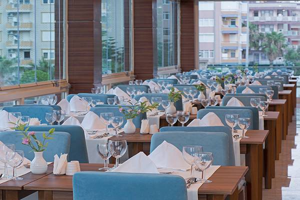 Ein gut eingerichtetes Restaurant im Asia Beach Resort & Spa mit blauen Stühlen und weißen Tischdecken.