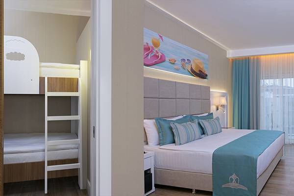 Doppelzimmer im Asia Beach Resort & Spa mit Doppelbett, Arbeitsbereich und Schlafbereich mit Etagenbetten.