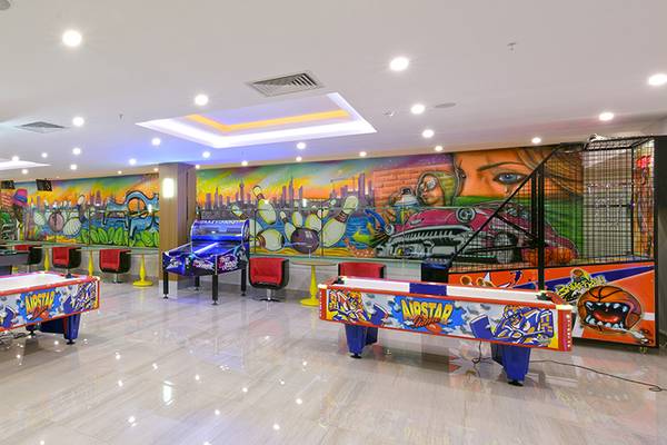 Spielzimmer im Asia Beach Resort & Spa mit bunten Spieltischen und einer Graffitiwand.