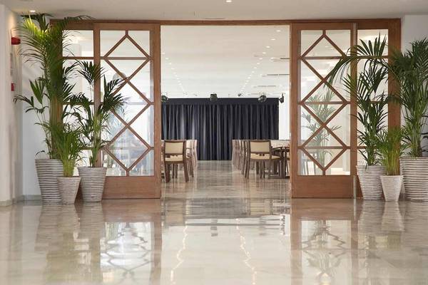 Eingangsbereich des Alua Leo Hotels mit Palmen und gefliestem Boden