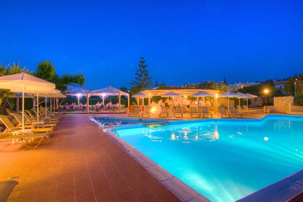 Poolbereich im Solimar Dias Hotel bei Nacht mit beleuchteten Schirmen und Lounge-Stühlen.
