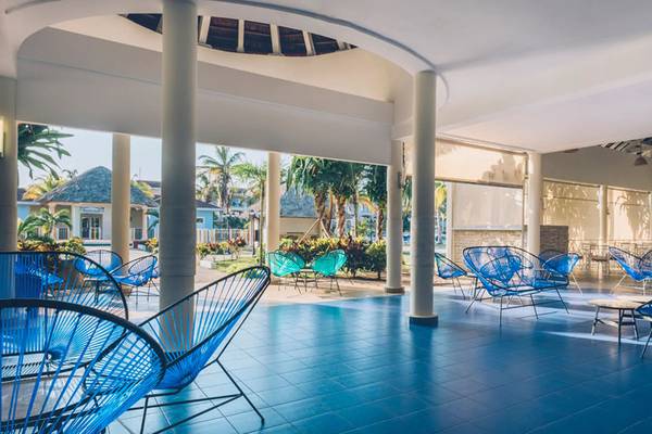 Loungebereich des Iberostar Laguna Azul Hotels mit blauen Stühlen und Tischen.