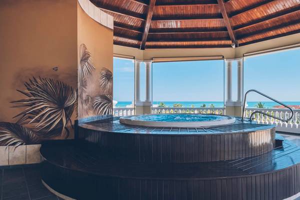Gazebo Whirlpool im Iberostar Laguna Azul mit Meerblick und tropischen Wandmalereien.