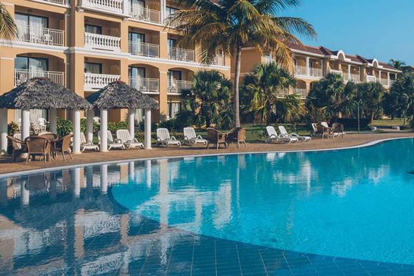 Außenpool des Iberostar Laguna Azul Hotels mit Lounge-Stühlen und Sonnenschirmen.