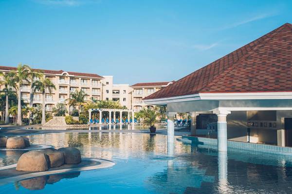 Außenpool des Iberostar Laguna Azul Hotels mit Lounge-Stühlen und Gebäuden im Hintergrund.