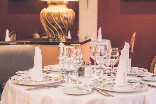 Ein gedeckter Tisch im Speisesaal des Iberostar Laguna Azul Hotels mit Tellern, Gläsern und Servietten.