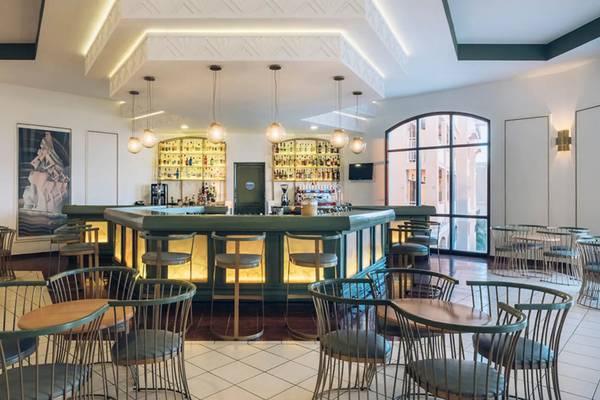 Bar im Iberostar Laguna Azul Hotel mit grüner Theke, hängenden Lampen und modernen Möbeln.