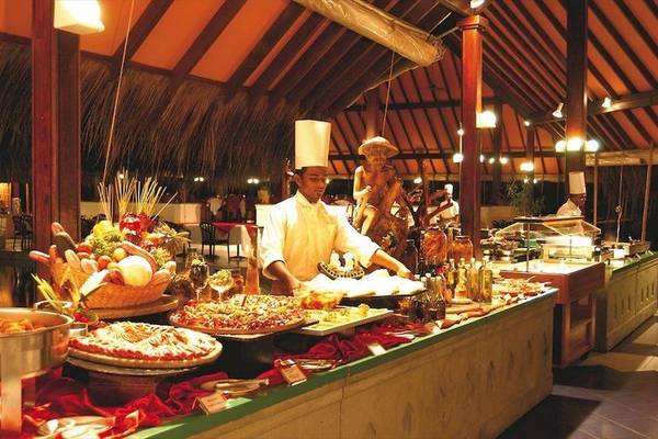 Buffet im Hotel Adaaran Club Rannalhi mit verschiedenen Gerichten und einem Koch, der serviert.