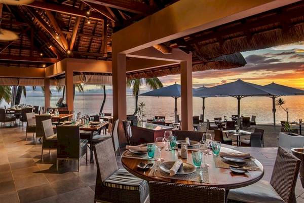 Innenansicht des Restaurants des Sugar Beach Mauritius mit Blick auf das Meer und den Sonnenuntergang.