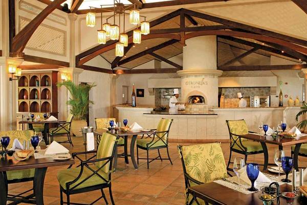 Innenansicht des Restaurants im Sugar Beach Mauritius Hotel mit gekochten Speisen und Tischen.
