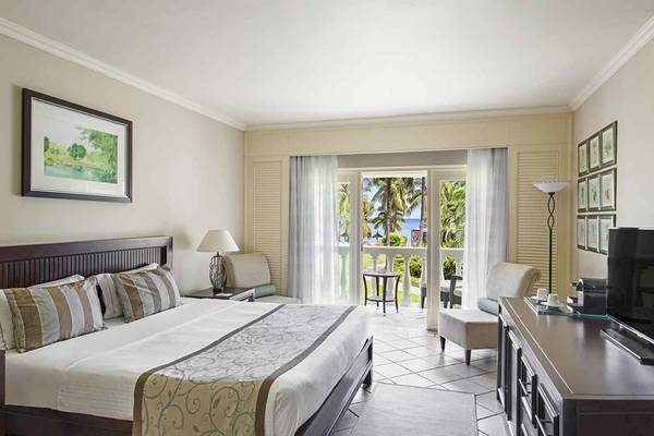 Hotelzimmer im Sugar Beach Mauritius mit Blick auf den Ozean und Möbeln.
