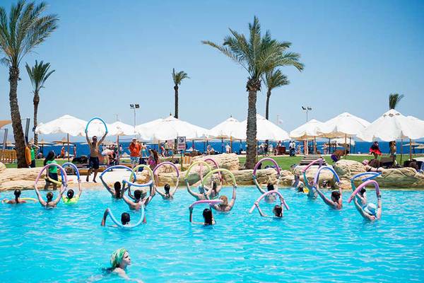 Gruppe von Schwimmern praktiziert Aquagymnastik im Pool des Amphoras Beach Hotels